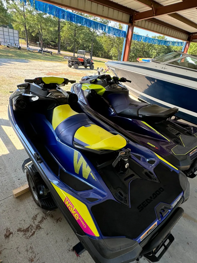 Slide: The Image of 2021 Sea-Doo Wake Pro 230 jet skis parked under a shelter. - 10