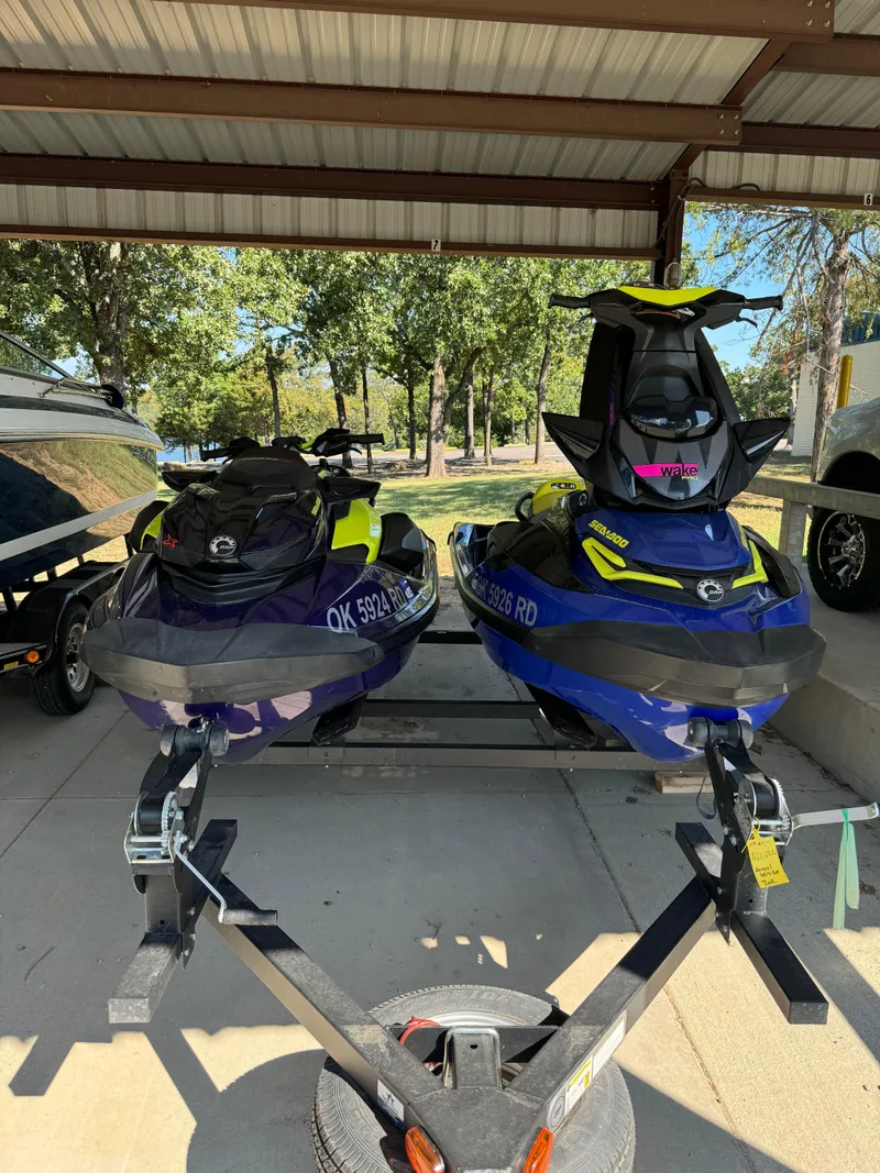 Slide: The Image of Two 2021 Sea-Doo Wake Pro 230 jet skis on a trailer under a metal canopy. - 11