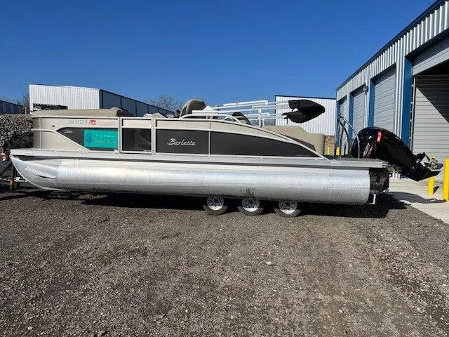 Slide: The Image of 2023 Barletta Cabrio 22UC pontoon boat parked outdoors near storage units. - 1