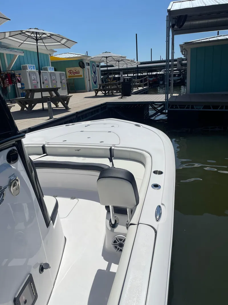 Slide: The Image of 2025 Tidewater Carolina Bay boat docked at a marina with picnic tables and umbrellas. - 7