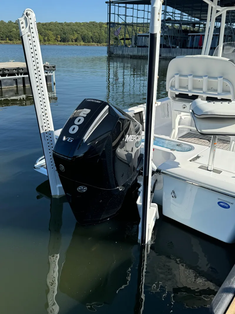 Slide: The Image of 2025 Tidewater 2110 Bay Max boat with Mercury 200 V6 engine docked on calm water. - 8