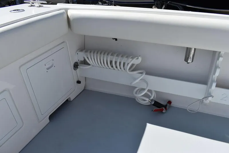 Slide: The Image of 2023 Steiger Craft 31 Miami boat interior with coiled hose and storage compartment. - 37