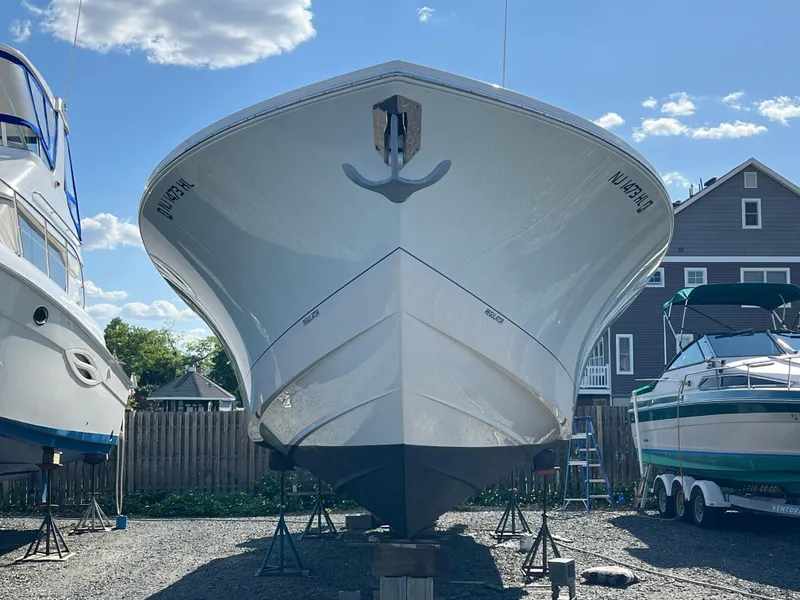 Slide: The Image of 2019 Regulator 41 boat on dry dock, surrounded by other boats, under a clear blue sky. - 2
