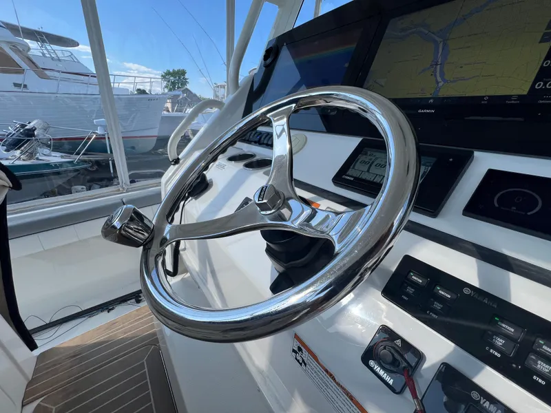 Slide: The Image of 2019 Regulator 41 boat helm with steering wheel and navigation display. - 34