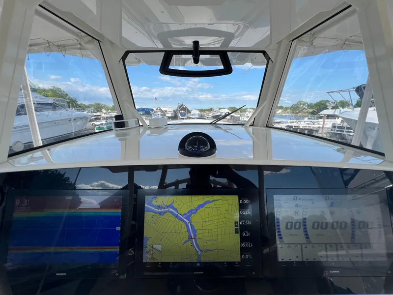Slide: The Image of 2019 Regulator 41 boat cockpit with navigation screens and scenic marina view. - 40