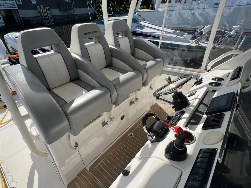 Slide: The Image of 2019 Regulator 41 boat cockpit with three cushioned seats and modern control panel. - 45