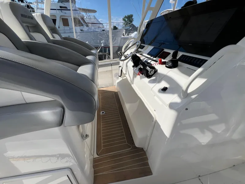 Slide: The Image of 2019 Regulator 41 boat interior with helm, seating, and navigation equipment. - 48
