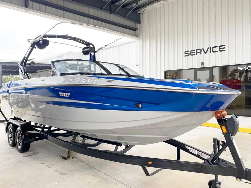 Slide: The Image of 2023 Supreme S240 boat in blue and white on a trailer at a service center. - 3
