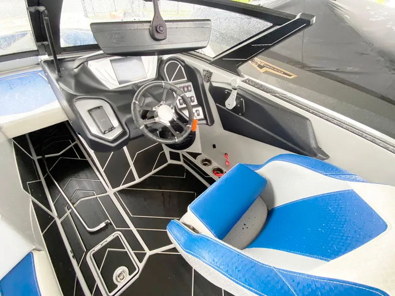 Slide: The Image of 2023 Supreme S240 boat interior with modern dashboard and blue seating. - 8