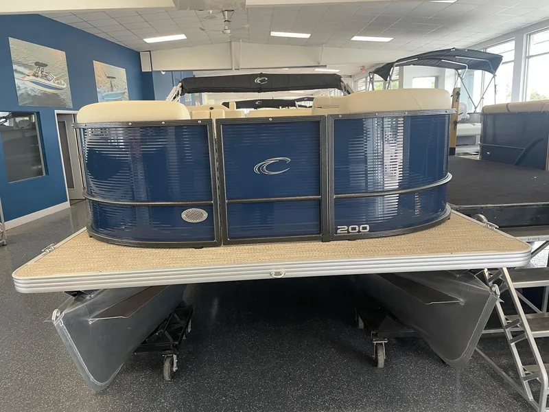 Slide: The Image of 2024 Crest 200L Classic LX pontoon boat in showroom, featuring sleek blue design. - 1