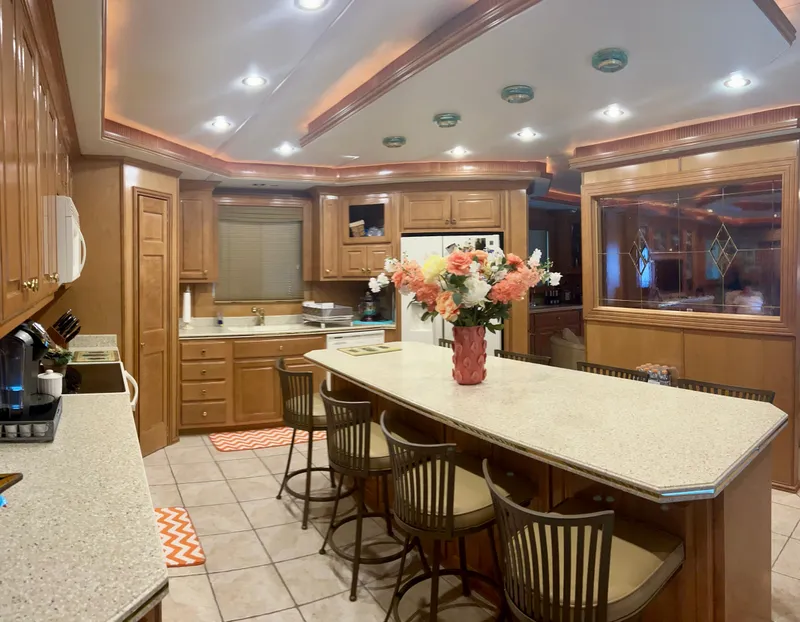 Slide: The Image of Luxurious 2004 Fantasy houseboat kitchen with island, bar stools, and floral centerpiece. - 10