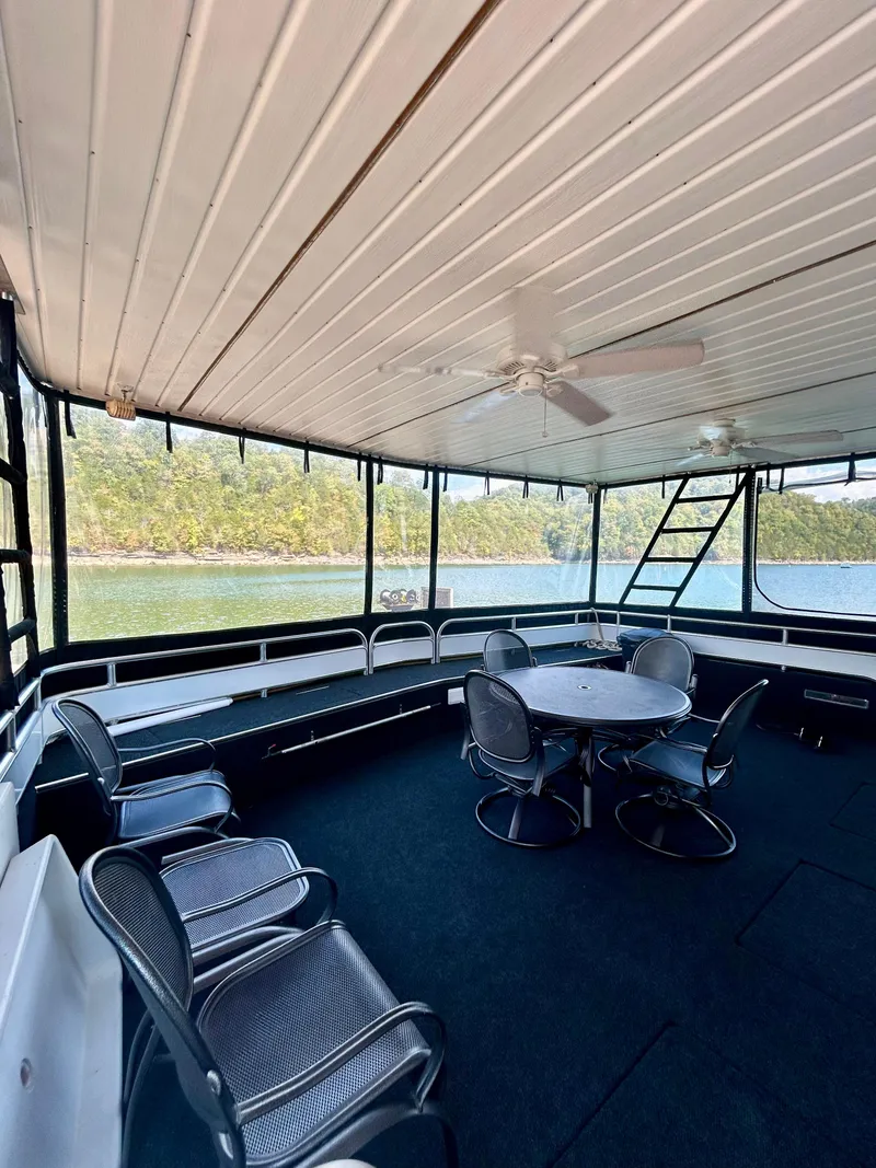 Slide: The Image of Spacious 2004 Fantasy houseboat interior with seating, table, and scenic water views. - 2