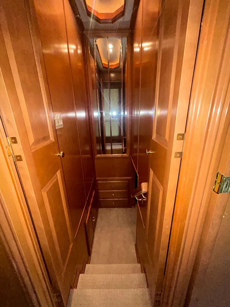 Slide: The Image of Narrow wooden hallway inside a 2004 Fantasy houseboat, featuring stairs and mirrored walls. - 21