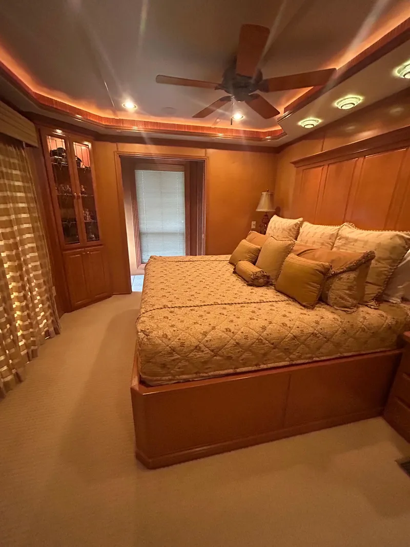 Slide: The Image of Luxurious bedroom in a 2004 Fantasy houseboat with elegant wood paneling and ambient lighting. - 24