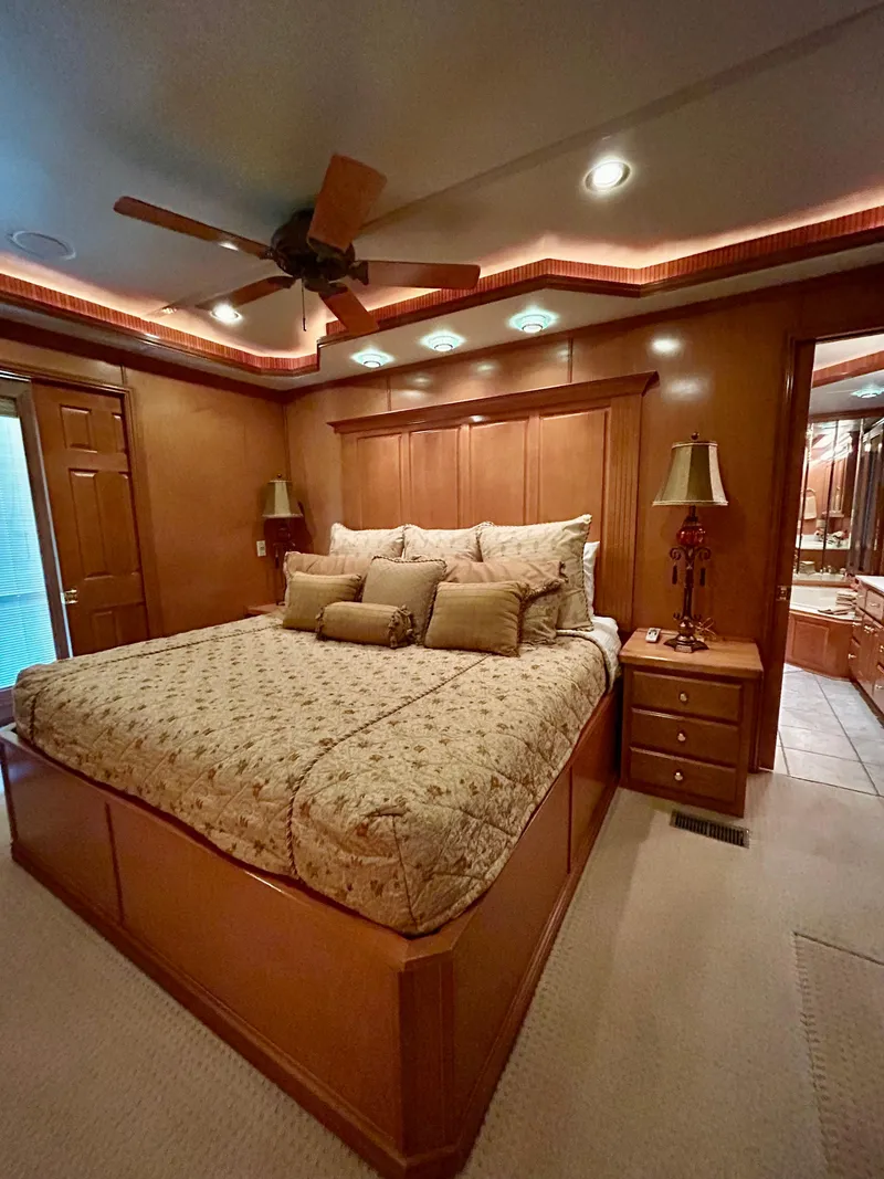 Slide: The Image of Luxurious bedroom in a 2004 Fantasy houseboat with elegant wood paneling and cozy bedding. - 26
