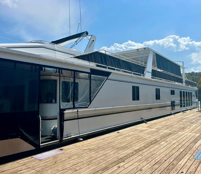 Slide: The Image of 2004 Fantasy houseboat docked under a clear blue sky. - 3
