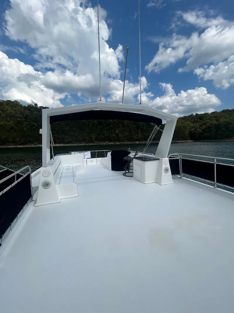 Slide: The Image of 2004 Fantasy houseboat deck with canopy, surrounded by water and lush greenery under a cloudy sky. - 32