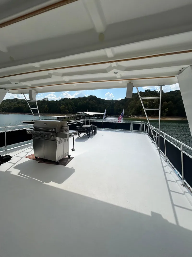 Slide: The Image of Spacious deck of a 2004 Fantasy houseboat with grill, overlooking serene waters and lush greenery. - 34