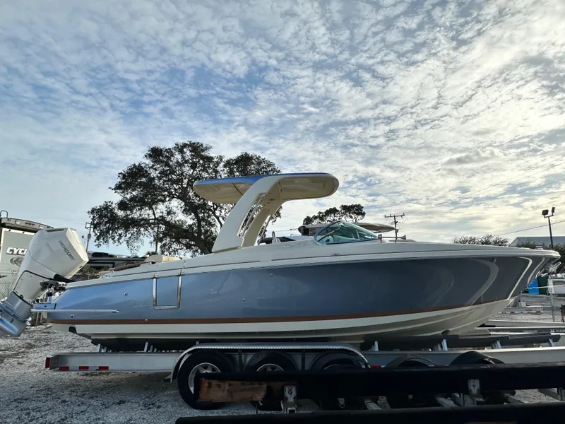 The Image of 2025 Chris-Craft Launch 28 GT boat on trailer under cloudy sky. - 0