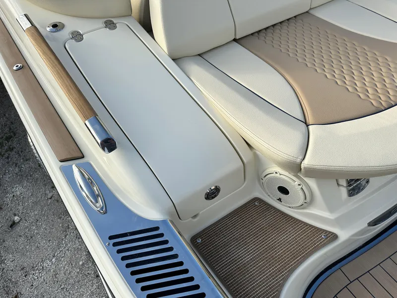 Slide: The Image of 2025 Chris-Craft Launch 28 GT boat interior with beige and white seating, wood accents, and speaker. - 6