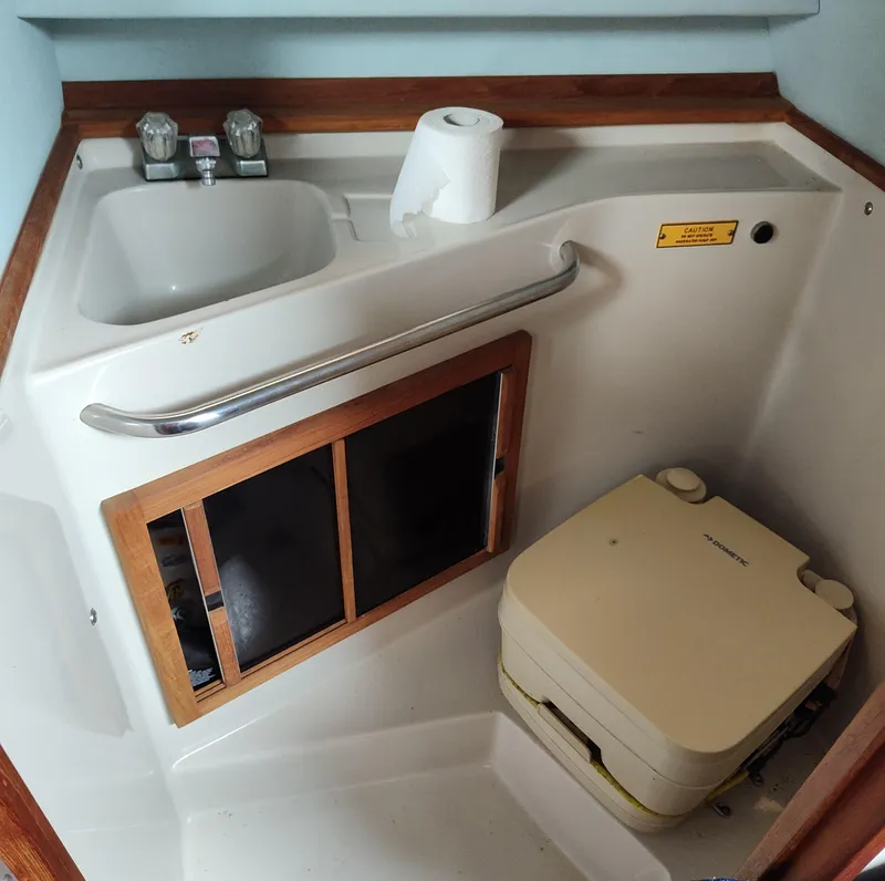 Slide: The Image of 1988 Sea Ray 268 DA boat bathroom with sink, toilet, and storage cabinet. - 8