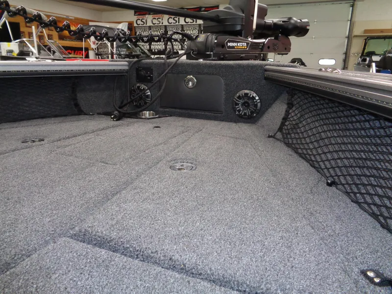 Slide: The Image of 2025 Lund 1875 Pro-V Sport boat interior with carpeted deck and storage compartments. - 13