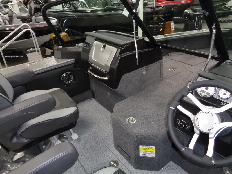 Slide: The Image of 2025 Lund 1875 Pro-V Sport boat interior with steering wheel and seating. - 16