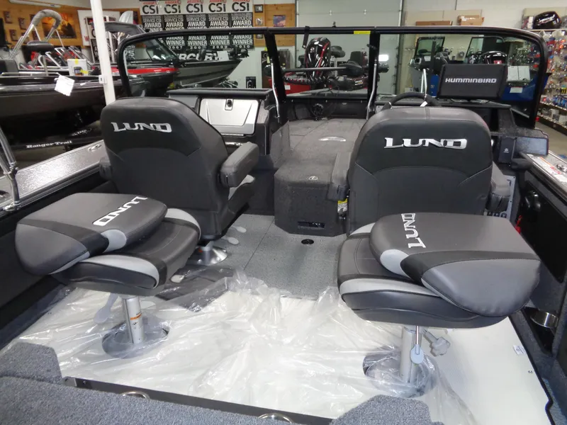 Slide: The Image of 2025 Lund 1875 Pro-V Sport boat interior with black seats and modern dashboard. - 20