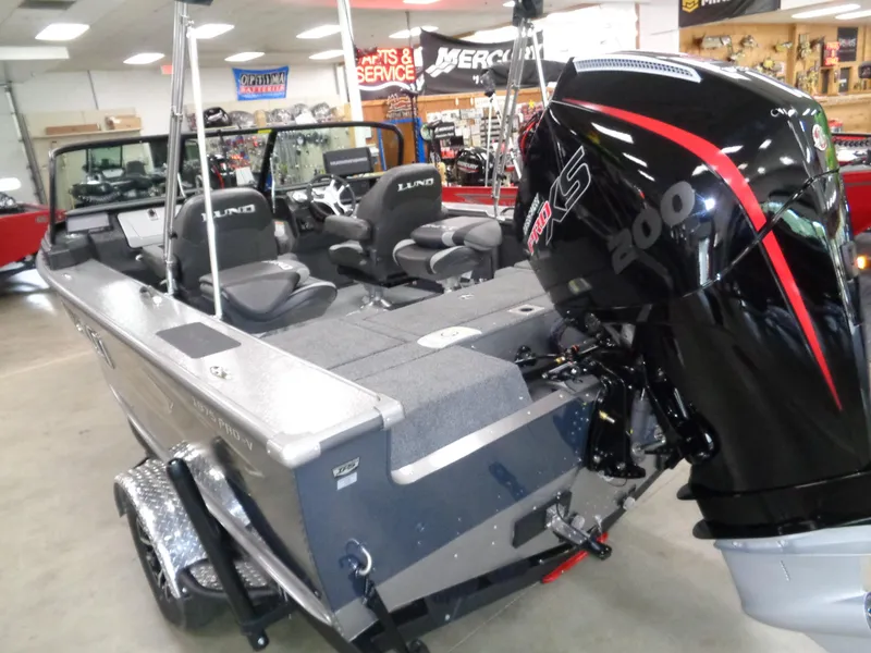 Slide: The Image of 2025 Lund 1875 Pro-V Sport boat with powerful outboard motor in showroom. - 6