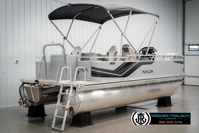 Slide: The Image of 2025 Avalon VEN RF pontoon boat in showroom with canopy and ladder. - 6