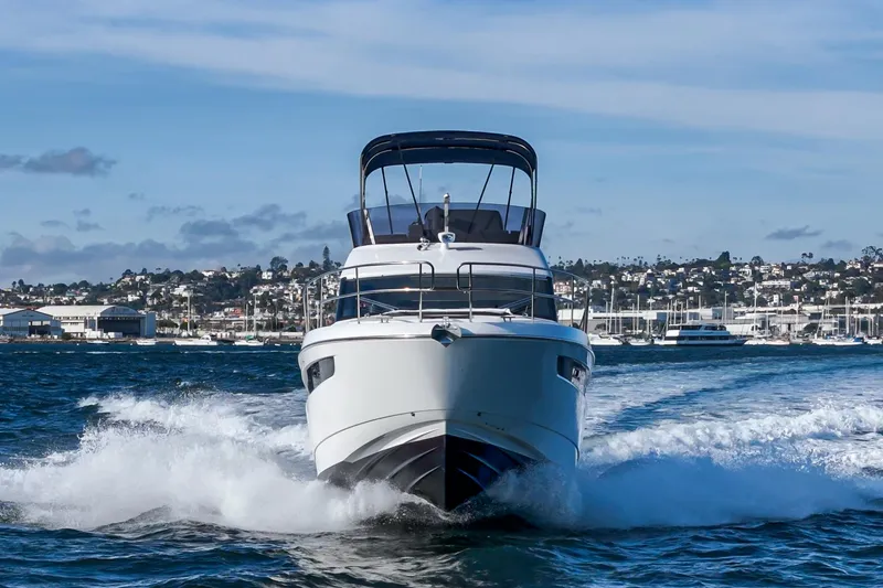 Slide: The Image of 2024 Bavaria R40 yacht cruising on open water with cityscape background. - 16