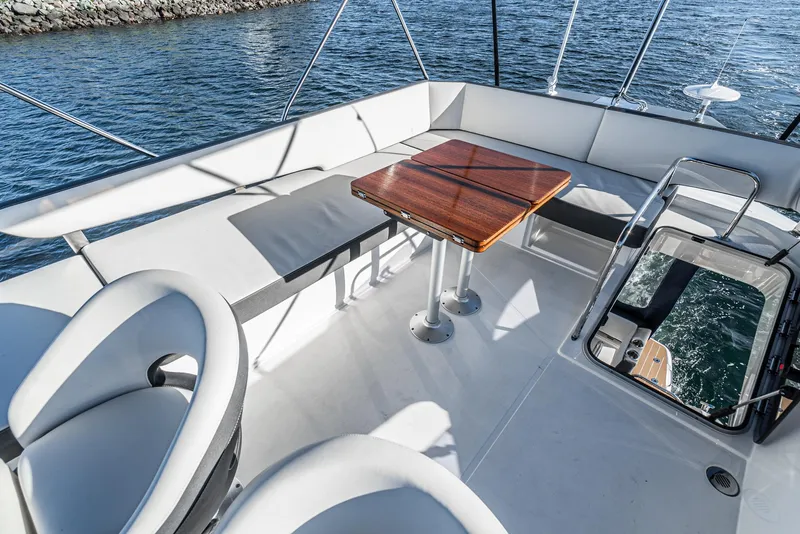 Slide: The Image of 2024 Bavaria R40 yacht deck with seating and wooden table, overlooking the water. - 36