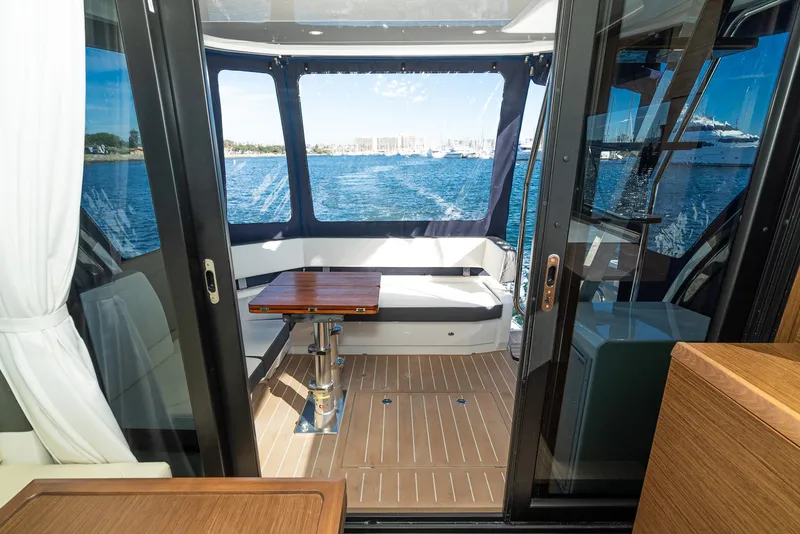 Slide: The Image of 2024 Bavaria R40 yacht interior with seating and table, overlooking the ocean. - 42