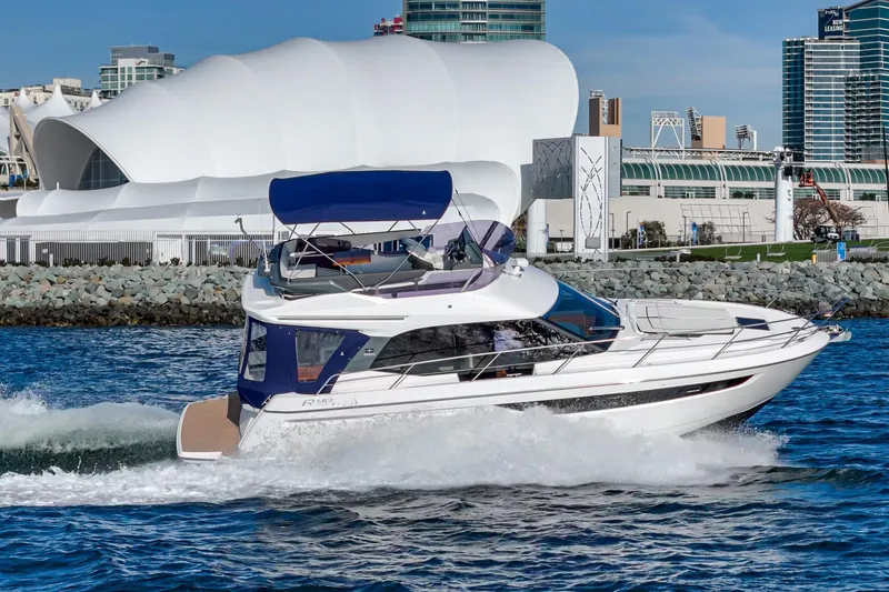 Slide: The Image of 2024 Bavaria R40 yacht cruising near modern waterfront architecture. - 6