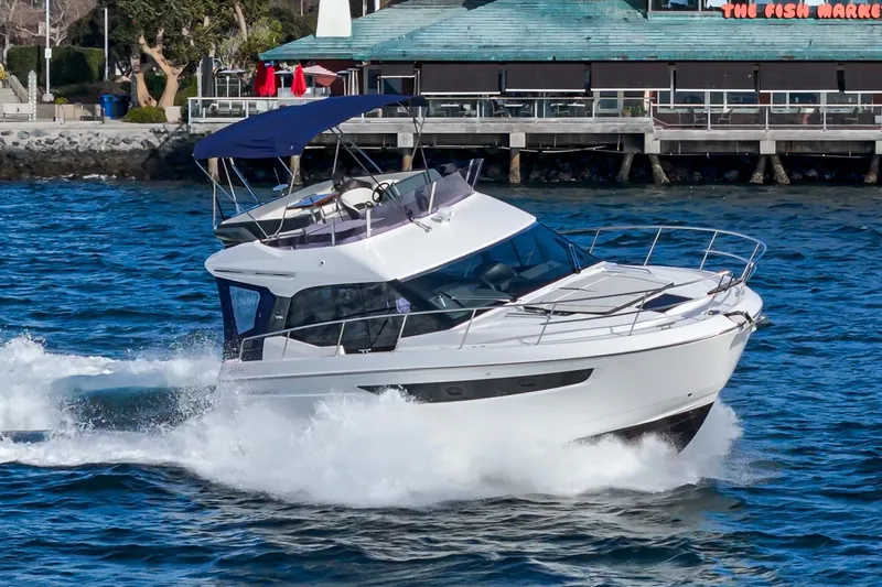 Slide: The Image of 2024 Bavaria R40 yacht cruising on blue water near a dock. - 7