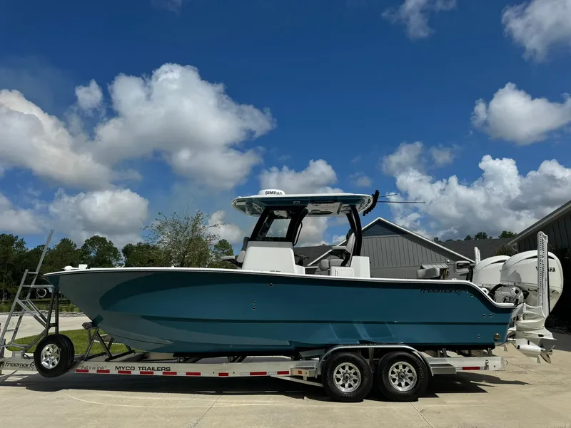 Slide: The Image of 2024 Freeman 28 boat on trailer under blue sky. - 1