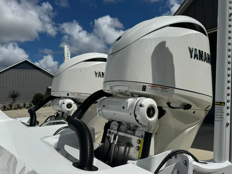 Slide: The Image of Twin Yamaha outboard motors on a 2024 Freeman 28 boat under a blue sky. - 12