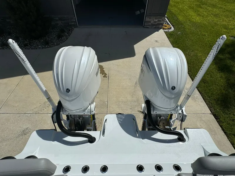 Slide: The Image of Twin outboard motors on a 2024 Freeman 28 boat, parked on a driveway. - 13