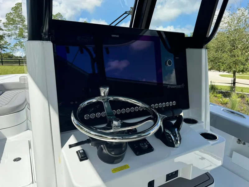 Slide: The Image of 2024 Freeman 28 boat dashboard with steering wheel and modern controls. - 29