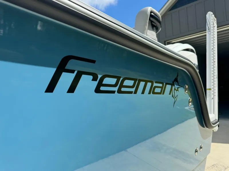 Slide: The Image of Freeman 28 boat, 2024 model, close-up of logo on blue hull. - 3