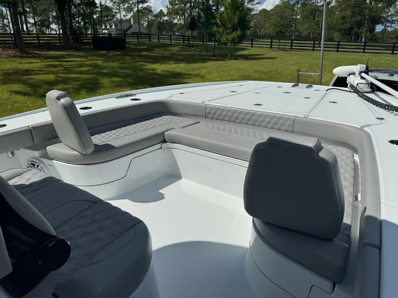 Slide: The Image of 2024 Freeman 28 boat interior with gray seating, set in a grassy outdoor area. - 41