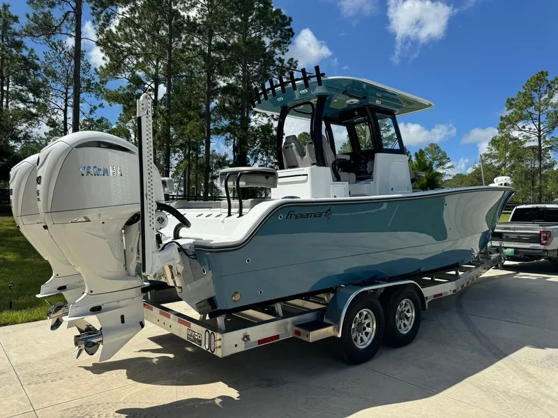 Slide: The Image of 2024 Freeman 28 boat on trailer with twin engines, parked outdoors. - 6