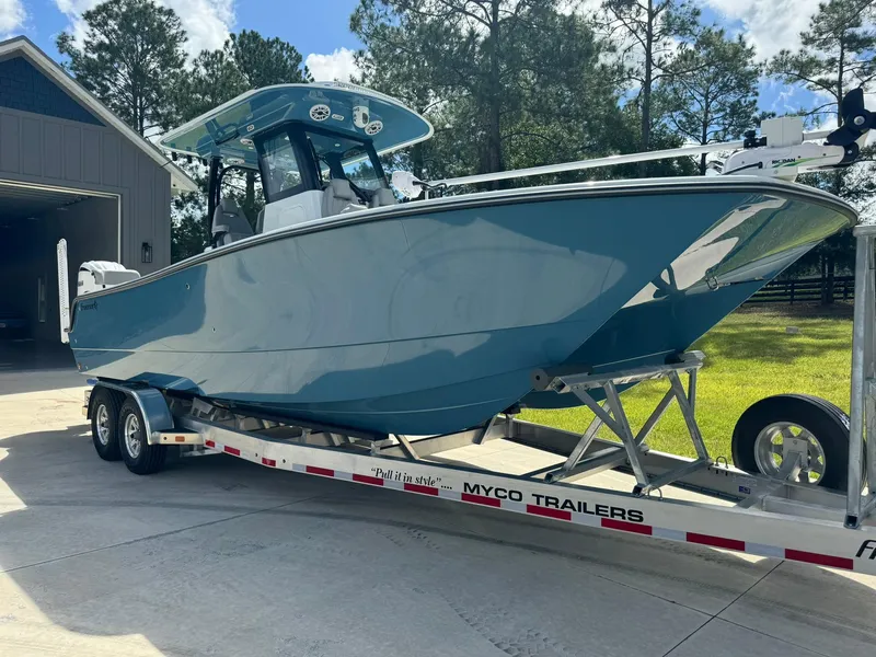 Slide: The Image of 2024 Freeman 28 boat on Myco trailer, parked outdoors near a garage. - 8