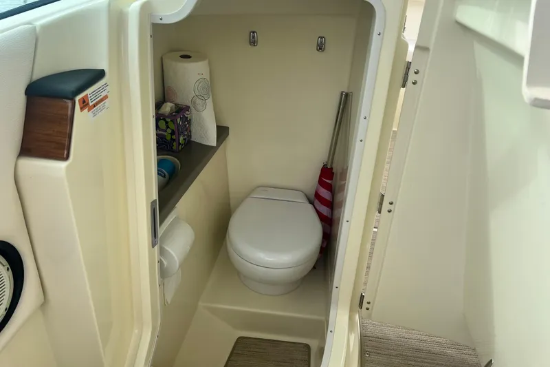 Slide: The Image of 2024 Chris-Craft Calypso 24 boat interior with compact bathroom and toilet amenities. - 19