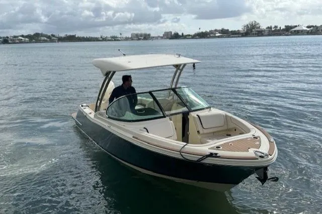 Slide: The Image of 2024 Chris-Craft Calypso 24 boat cruising on a calm waterway. - 2