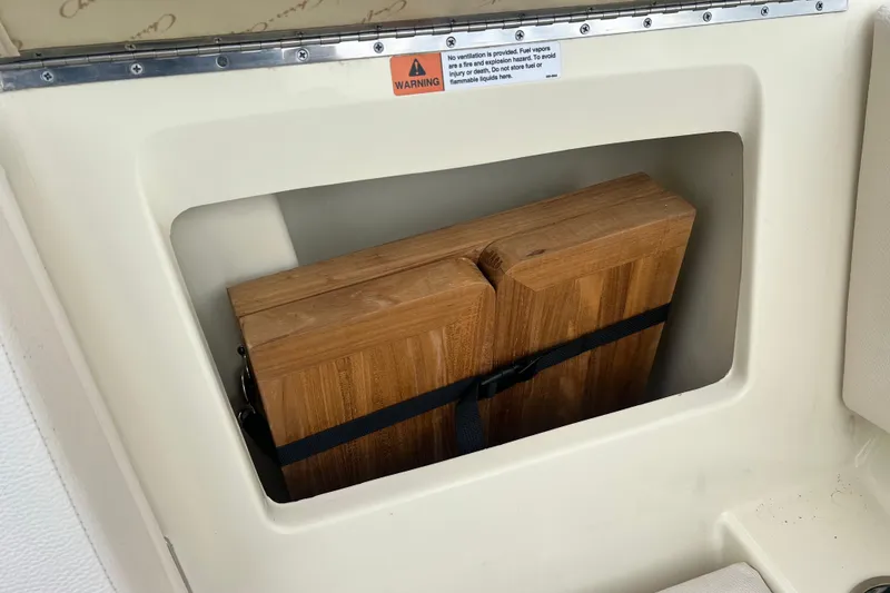 Slide: The Image of 2024 Chris-Craft Calypso 24 storage compartment with wooden panels secured inside. - 20