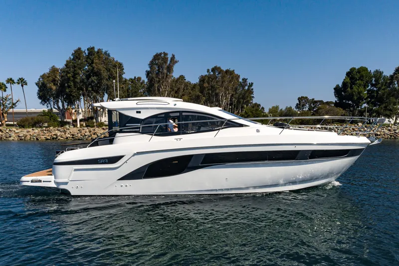 Slide: The Image of 2024 Bavaria SR41 yacht cruising on a calm waterway, surrounded by trees. - 17