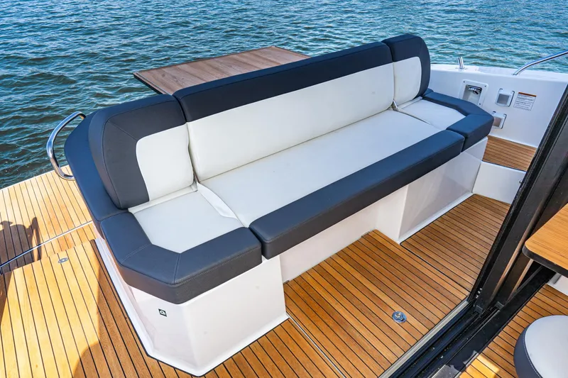 Slide: The Image of 2024 Bavaria SR41 yacht with sleek seating on teak deck, overlooking water. - 33