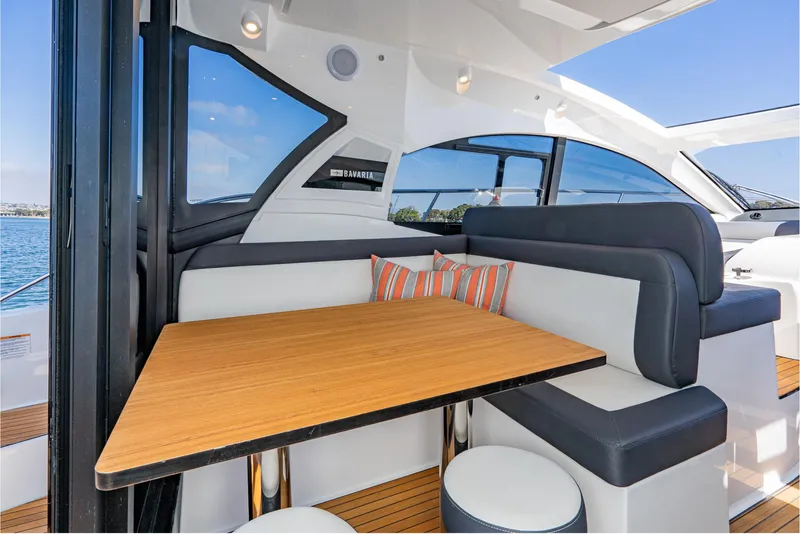 Slide: The Image of 2024 Bavaria SR41 yacht interior with modern seating and wooden table, featuring ocean view. - 38