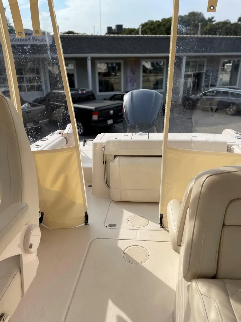 Slide: The Image of 2019 Grady-White 235 Freedom boat interior with beige seating and clear canopy. - 10
